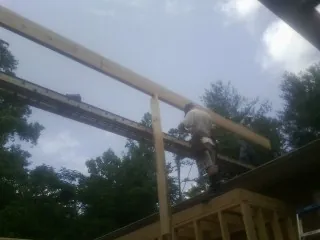 Carpenter setting a ridge beam over a new addition frame — Ice Dam Removal by Roofing Brothers in Tustin