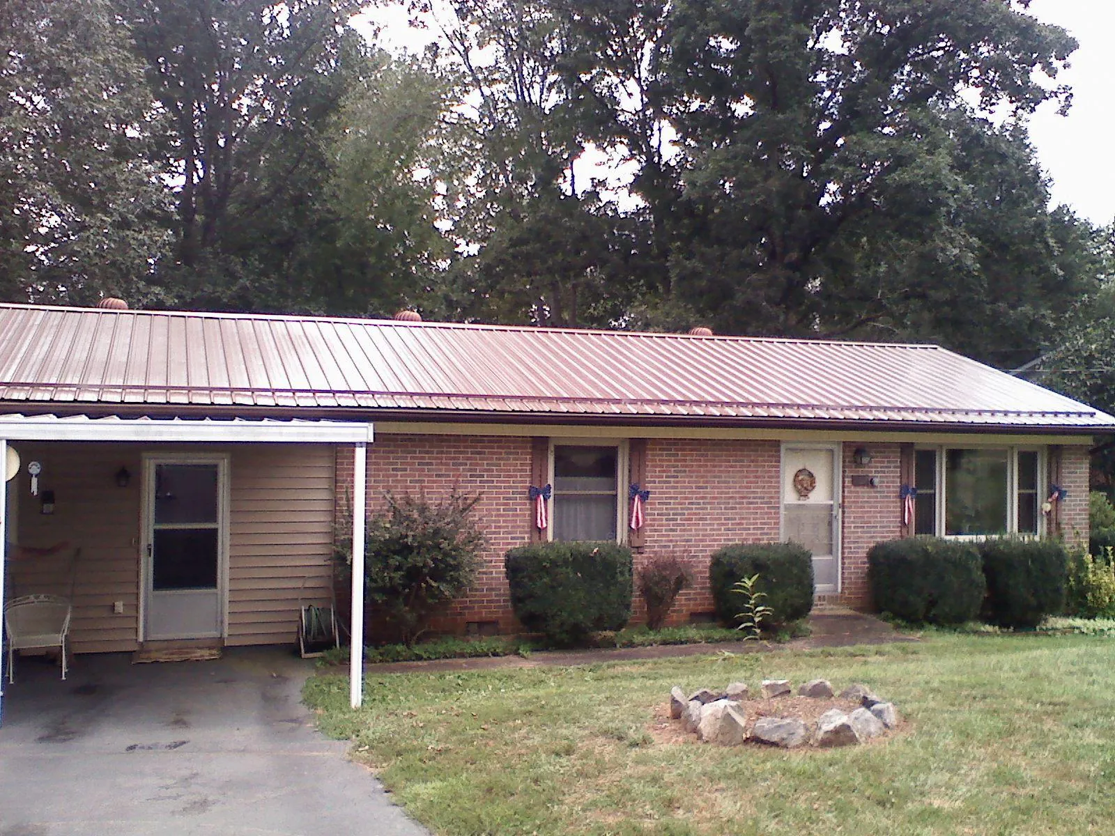 Bronze metal roof and carport on a brick ranch home — Roof Repair work by our crew in Tustin
